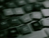 A blurred close-up of laptop keyboard keys, shot at an angle.